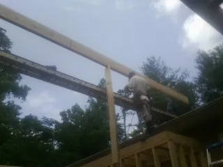 Carpenter setting a ridge beam over a new addition frame — Ice Dam Removal by Roofing Brothers in Mc Clellandtown