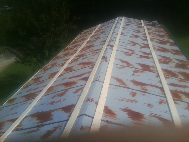 Rusted metal roof panels with new wood purlins before replacement — Storm Damage Roof Repair in Mc Clellandtown by Roofing Brothers