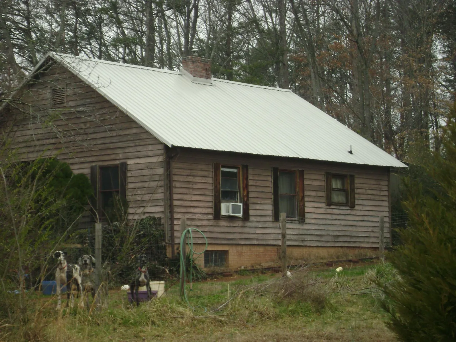 White metal roof on an old wood sided farmhouse, from a Metal Roof Installation job in Mc Clellandtown